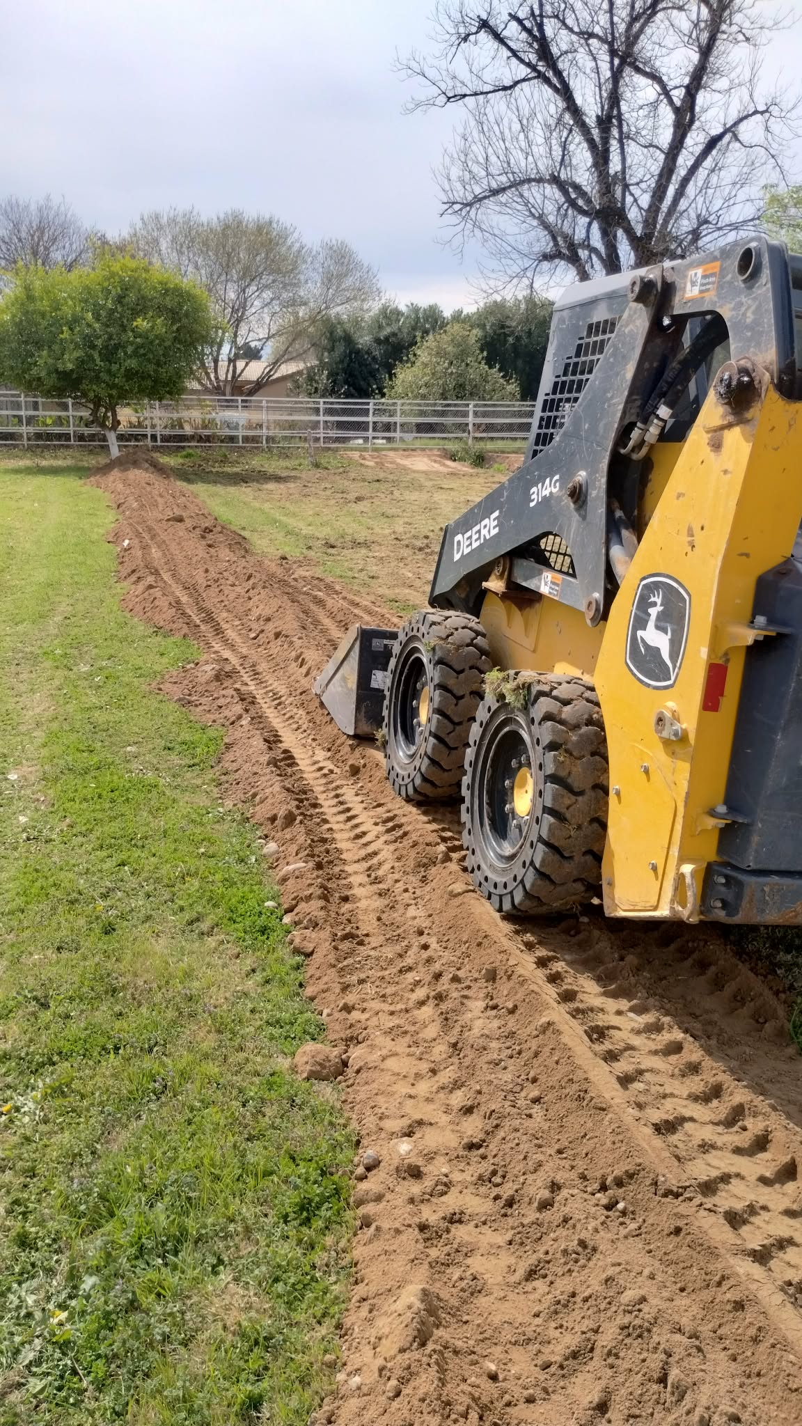 Skid steer finish grading soil