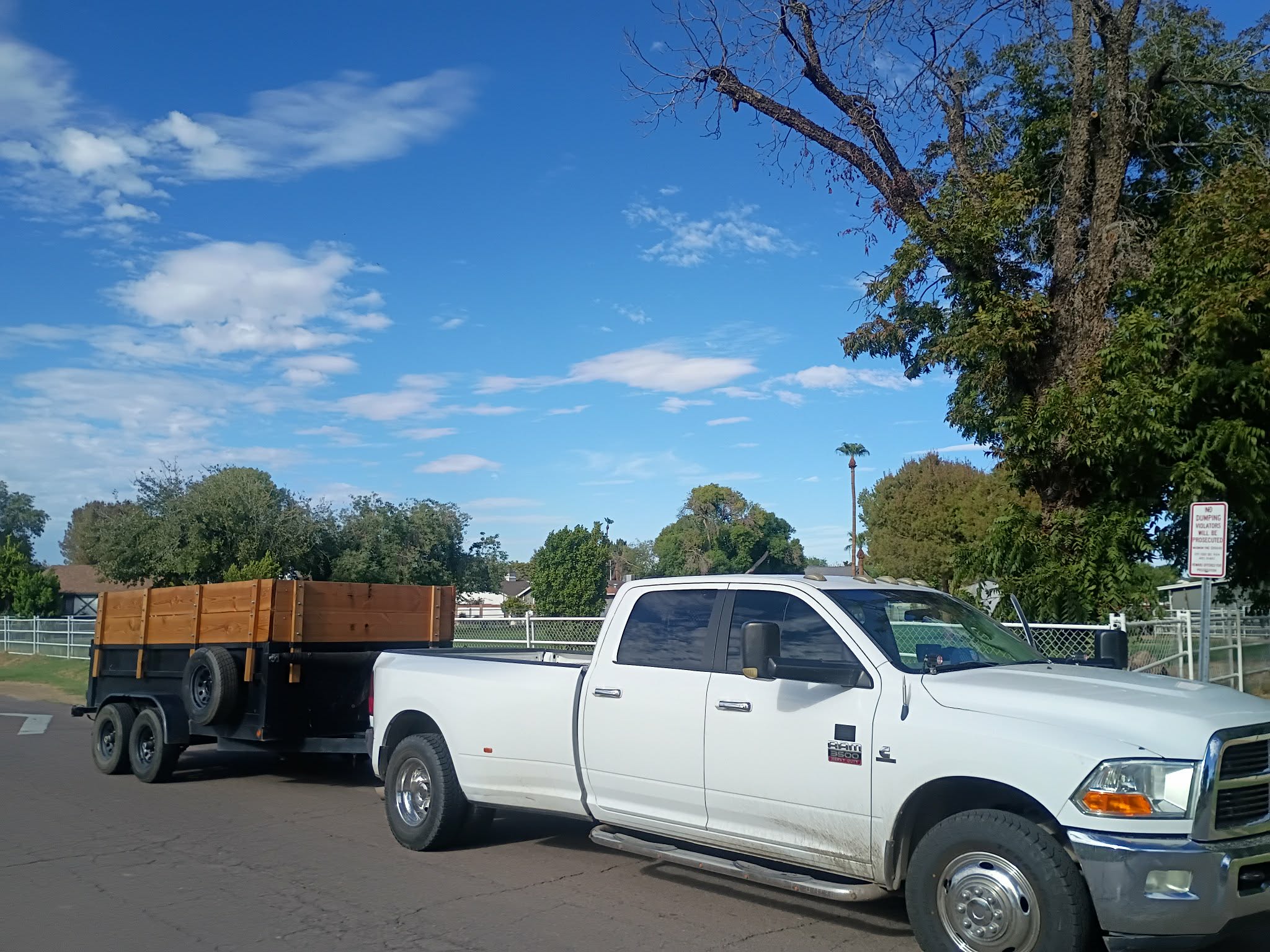 White truck with large dump trailer with wood boards